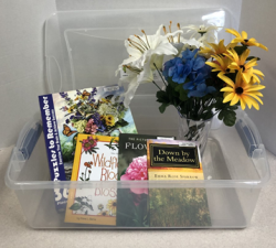 The flower memory kit includes a vase, bouquet of flowers, a puzzle, 3 books, and a plastic bin.